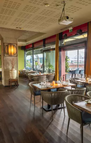 Heller Wintergarten mit gedeckten Tischen und Panoramablick im am kai Hamburg