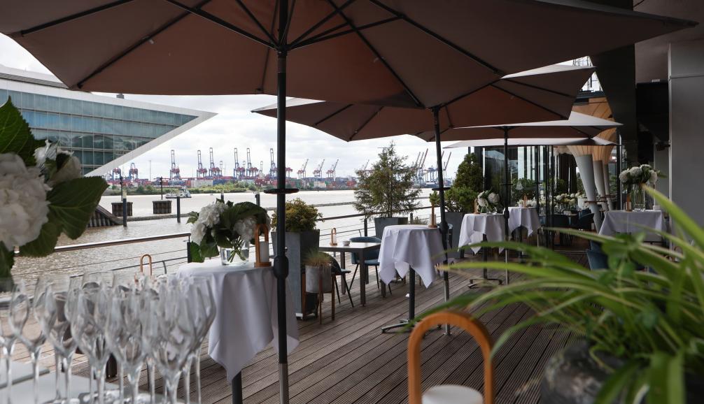 Hochzeitsfeier auf der Terrasse am kai Hamburg – festlich gedeckte Tische mit Blick auf die Elbe und den Hafen