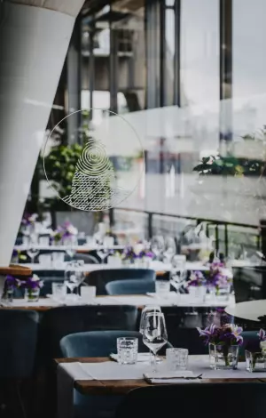 Hochzeitstische im am kai Hamburg mit Blumendekoration und Glasfront zur Elbe