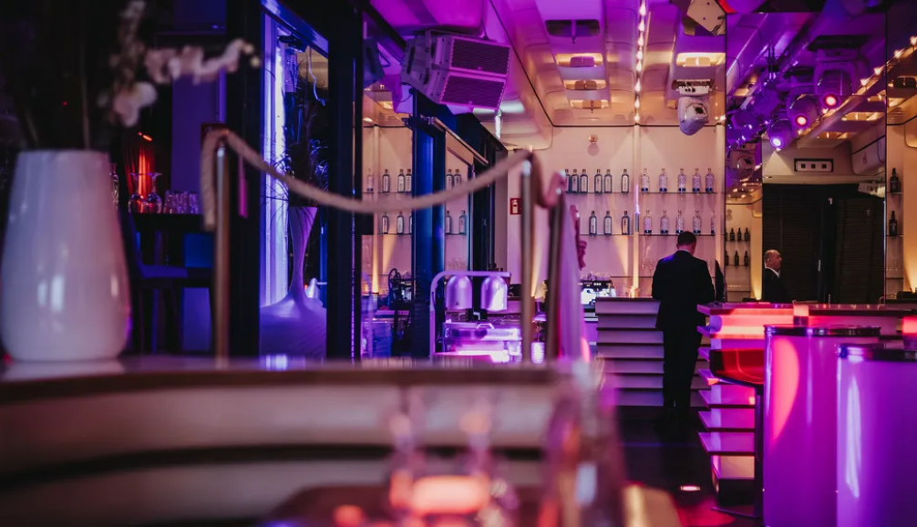 Innenraum des am kai Club – Bar und Lounge mit violett-goldener Beleuchtung für Weihnachtsfeiern